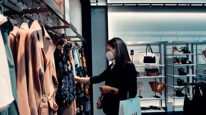 Shopping Clothes - woman in black long sleeve shirt standing in front of clothes